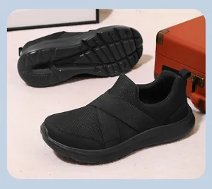 Side and sole view of black mesh slip-on sneakers with elastic cross-straps