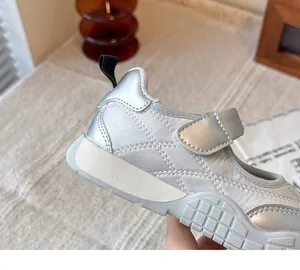 Primer plano de zapatilla Mary Jane plateada acolchada con detalles de costura
