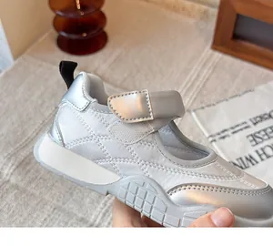 Primer plano de zapatillas Mary Jane plateadas para niña con costuras acolchadas y tira