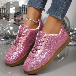 Close-up of pink glitter sneakers with holographic tongue and brown flat sole