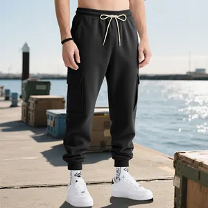 Full view of men's heavy black cargo jogger pants in an outdoor harbor setting