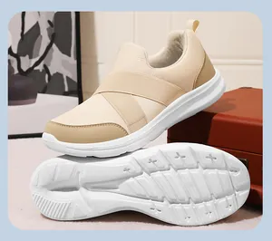 Detailed view of beige slip-on sneakers showing the elastic straps and non-slip white sole