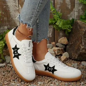 Vista detallada de zapatillas blancas casuales para mujer con estrella negra y suela de goma
