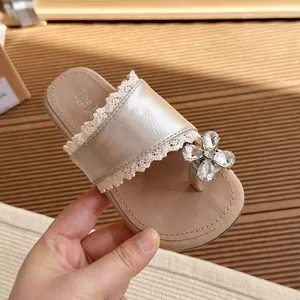 Champagne gold girls' toe-post slippers with lace trim and crystal flower detail