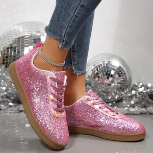 Macro view of pink glitter sneakers with sparkling texture and disco ball background
