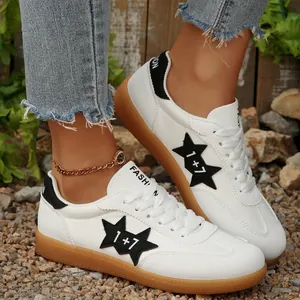 Detalle de zapatillas casuales blancas con parches de estrellas y suela marrón