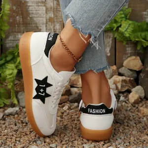 Detalle de zapatillas blancas informales para mujer con estrella negra y suela de goma