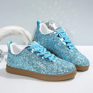 Close-up of blue glitter sneakers featuring sparkling sequins and brown rubber soles