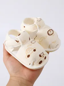 Detailweergave van zachte baby sandalen met schattige patronen van een auto en een leeuw.