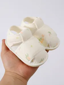 Detail van baby bloemen sandalen met zachte anti-slip zool vastgehouden in de hand