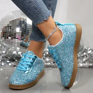 Sparkly light blue glitter flat casual sneakers with brown rubber soles shown on feet
