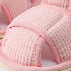 Gedetailleerde weergave van roze ademende babysandalen met zachte antislipzolen en wafeltun