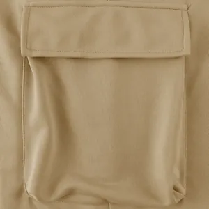 Macro view of a large flap cargo pocket on khaki heavyweight men's street style trousers