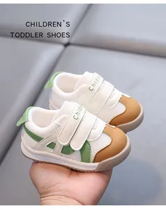 Close-up of breathable mesh toddler shoes with green accents and velcro straps.