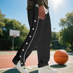 Detailed view of black men's hip-hop basketball snap pants with side stripes on court