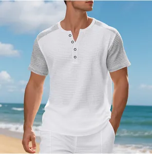 Oversized men's waffle knit Henley short sleeve shirt with grey color-block on beach.