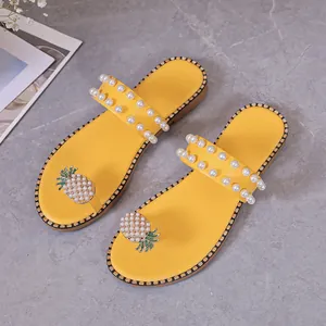Elegant yellow flat sandals with pearl straps and decorative pineapple toe design details