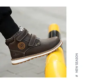 Une vue latérale détaillée de bottines Martin marron pour enfants en plein air.