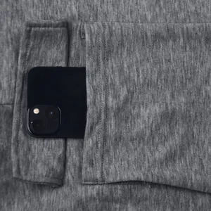 Detail of deep side pocket on grey cargo pants with a smartphone showing capacity.