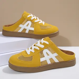 Dettaglio di sneaker mule in rete gialla con lacci bianchi e suola in gomma marrone