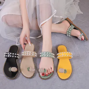 Macro view of pineapple rhinestone and pearl detail on colorful flat sandals