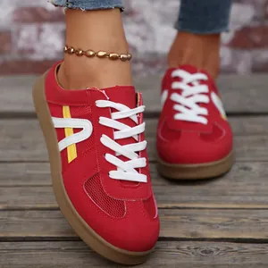 Dettaglio delle sneakers rosse da donna in mesh con lacci bianchi e suola in gomma marrone