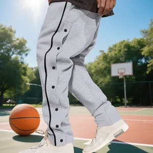 Close-up detail of grey tear-away basketball sweatpants with side snap buttons on court