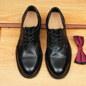 Handcrafted men's black cordovan leather Goodyear welted Derby shoes on wood background