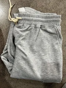 Detail of grey heavyweight sweatpants showing drawstring waist and care instructions label.