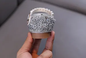 Nahaufnahme der glitzernden silbernen Strasssteine an einem Mädchen Prinzessinnenschuh