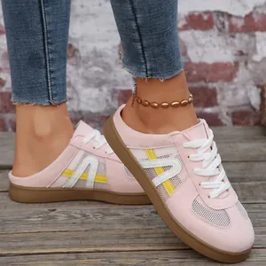 Primo piano di scarpe da ginnastica rosa senza tallone con inserti in rete traspirante.