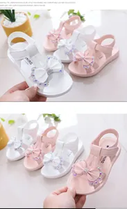 Detalle de sandalias de princesa para niñas con un lazo de diamantes de imitación.