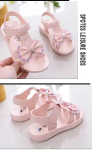 Vista detallada de sandalias rosas para niñas con lazo de strass y suelas blandas