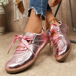 Vue détaillée de baskets German Trainer roses métallisées avec des lacets en ruban satin.