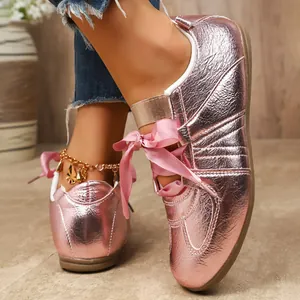 Gros plan sur les baskets GAT rose métallisé pour femmes avec lacets en ruban de satin chic