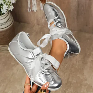 Gros plan de baskets GAT argentées élégantes avec lacets en ruban de satin blanc pur