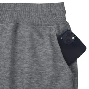 Close-up detail of a deep side pocket on grey heavyweight cotton sweatpants with a phone