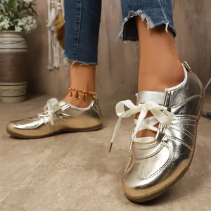 Vue détaillée de baskets GAT dorées pour femmes avec des lacets en ruban blanc élégants