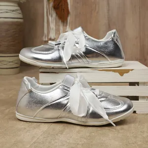 Vue latérale détaillée de baskets argentées avec des lacets en ruban blanc élégant