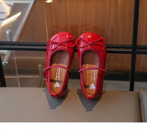 Detailed view of girls' shiny red patent leather Mary Jane shoes with a delicate bow