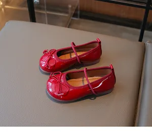 Close-up detail of red patent leather Mary Jane shoes for girls featuring a cute bow