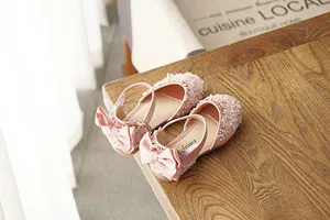 Detailed view of pink girls' princess shoes with crystal sequins and a satin bow detail.