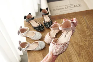 Close-up detail of pink girls crystal princess shoes with elegant bow and sequins