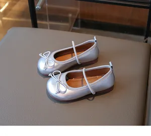 Detail view of silver girl's flats with a cute bow and metallic finish for toddlers.