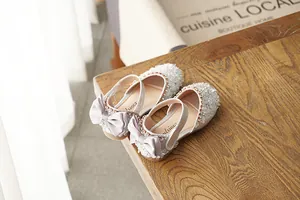 Detail view of sparkling girls' princess shoes with lavender satin bows