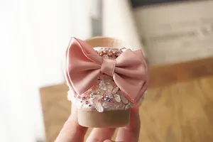 Close-up of pink girl's princess shoe heel with large bow and crystal embellishments.