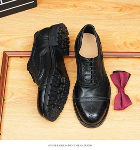 Detalle de zapatos brogue de cuero negro Goodyear sobre un fondo de madera rústica.