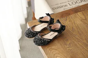 Close-up of black girls princess sandals featuring sparkling crystals and heel bow