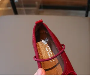 Macro detail of red patent leather toddler girl shoe with heart printed soft insole