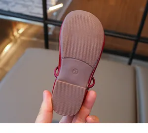 Detailed macro view of the non-slip rubber sole on red toddler girls' leather shoes